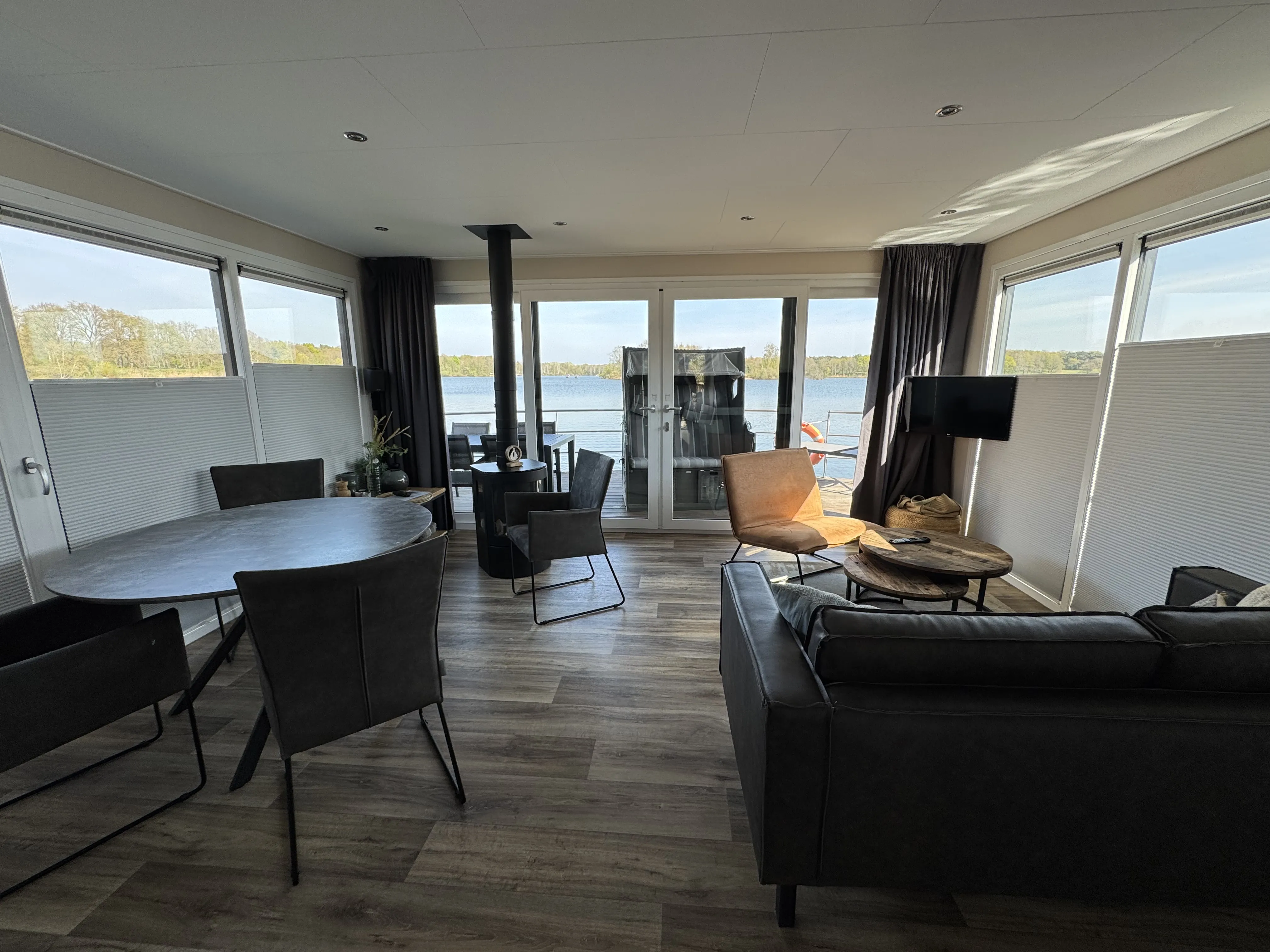 Wohnzimmer im schwimmenden Haus mit Panoramablick auf den See