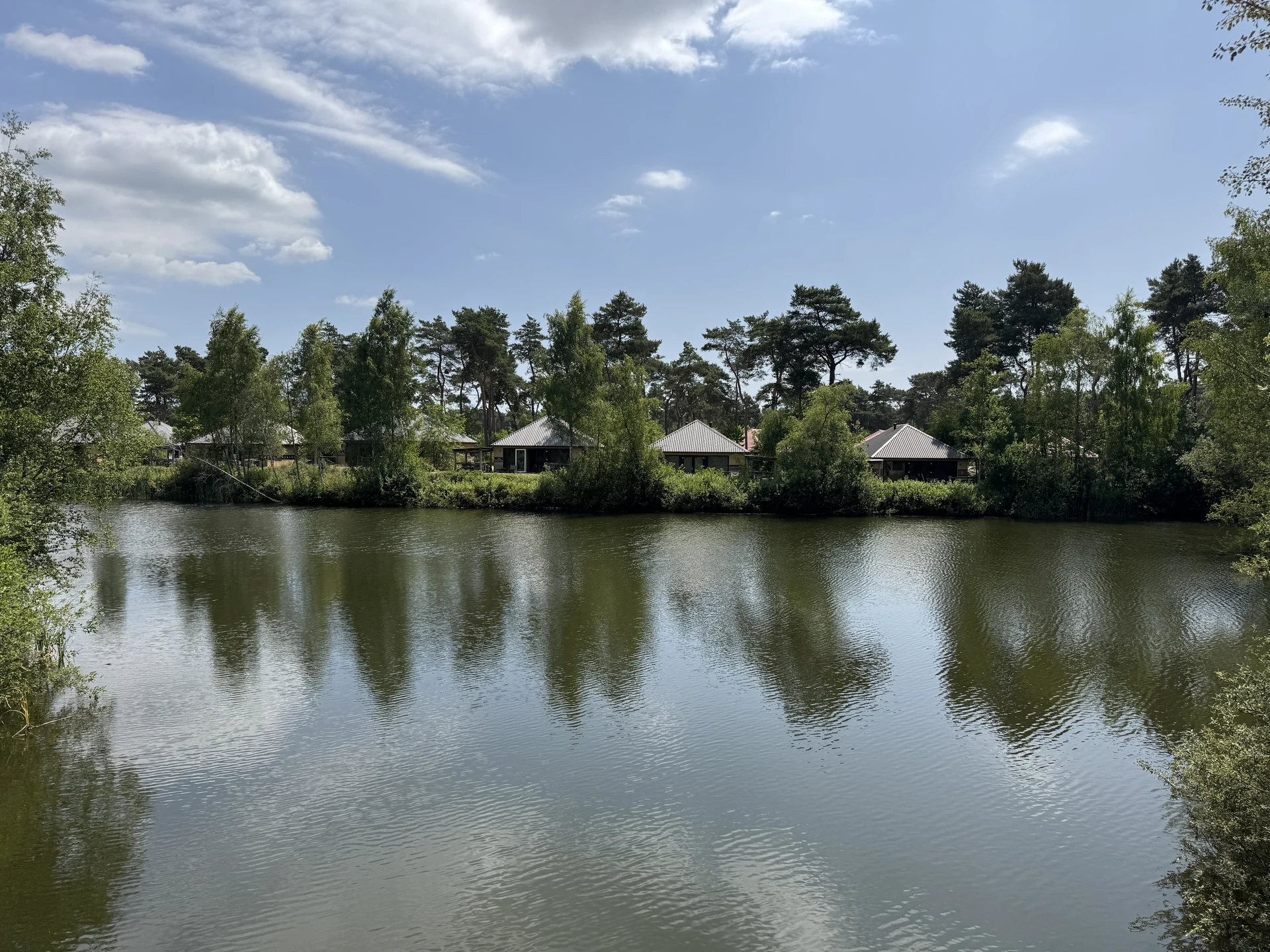 Ferienhäuser im Safari Resort Beekse Bergen am Wasser mit Holzfassade und Steg