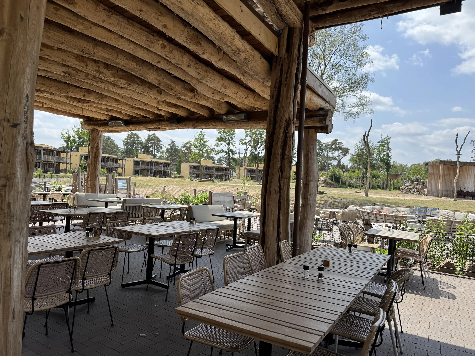 Weiterer Blick auf die Restaurantterrasse im Safari Resort Beekse Bergen mit Sitzgruppen und Bepflanzung