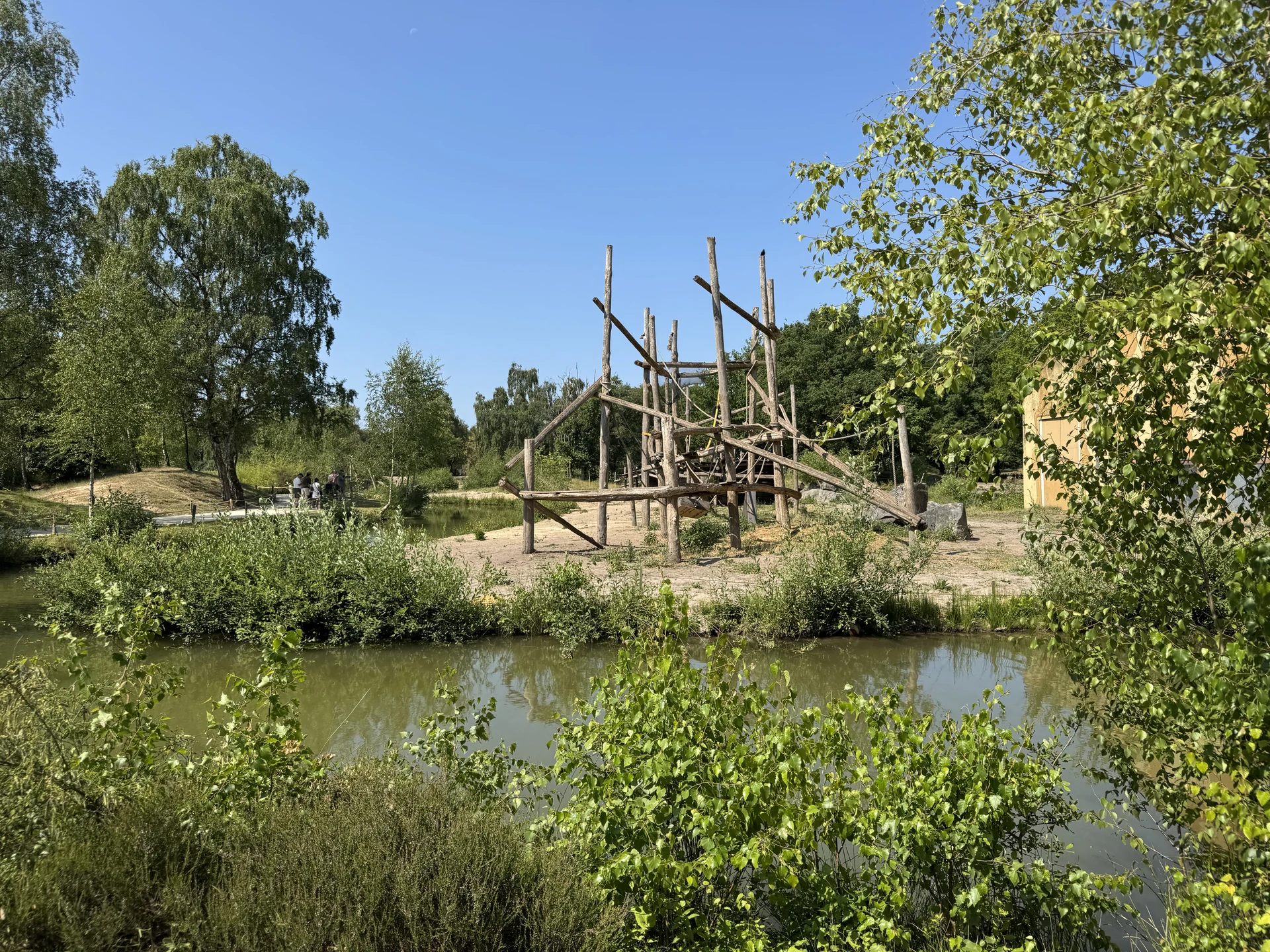 Großes Holz-Klettergerüst auf einer Sandinsel am Wasser im Safaripark Beekse Bergen
