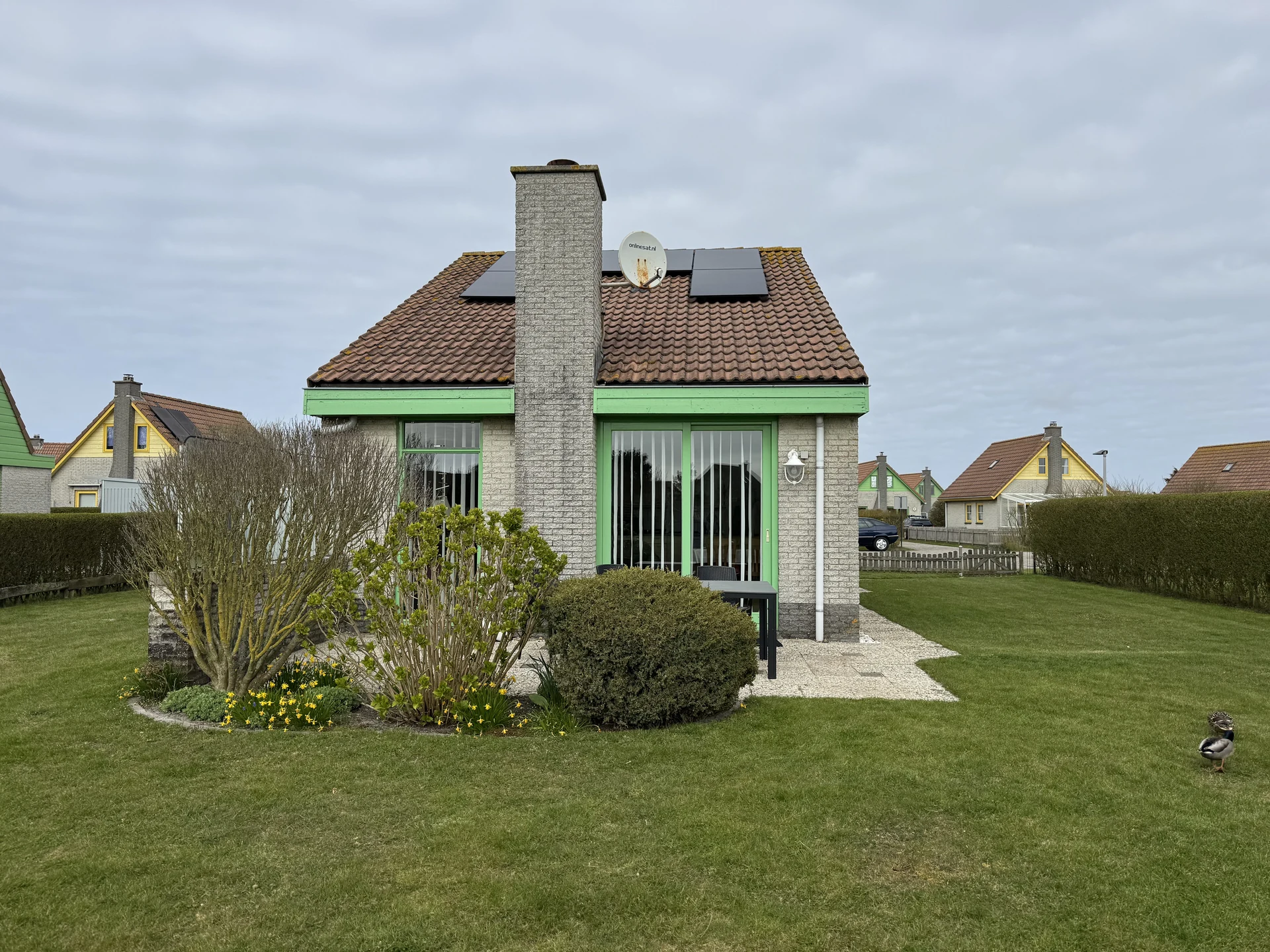 Bungalow mit Solaranlage und großer Rasenfläche im Bungalowpark Strandslag