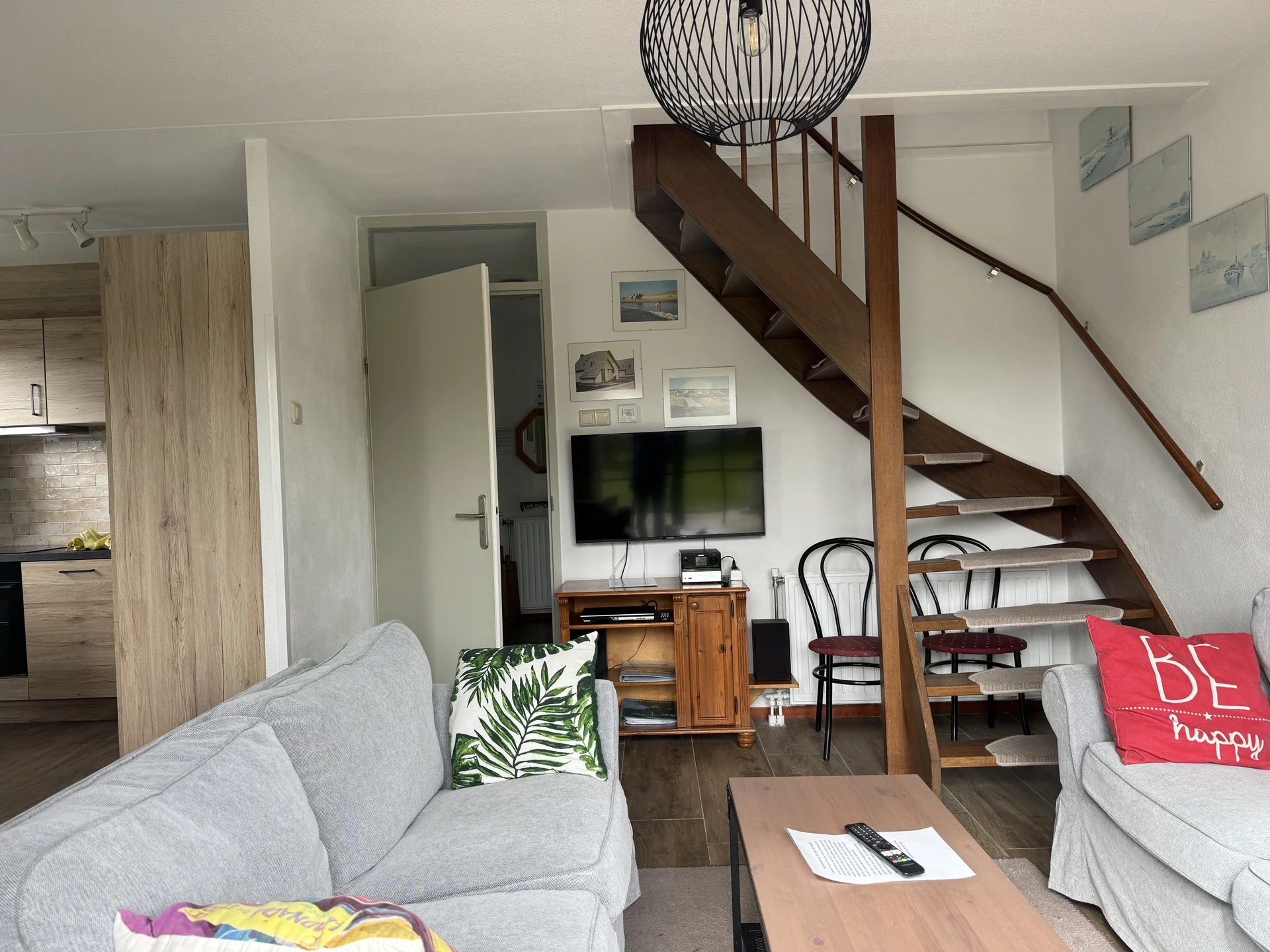 Wohnbereich eines Bungalows im Strandslag mit offener Holztreppe und Küchenzeile