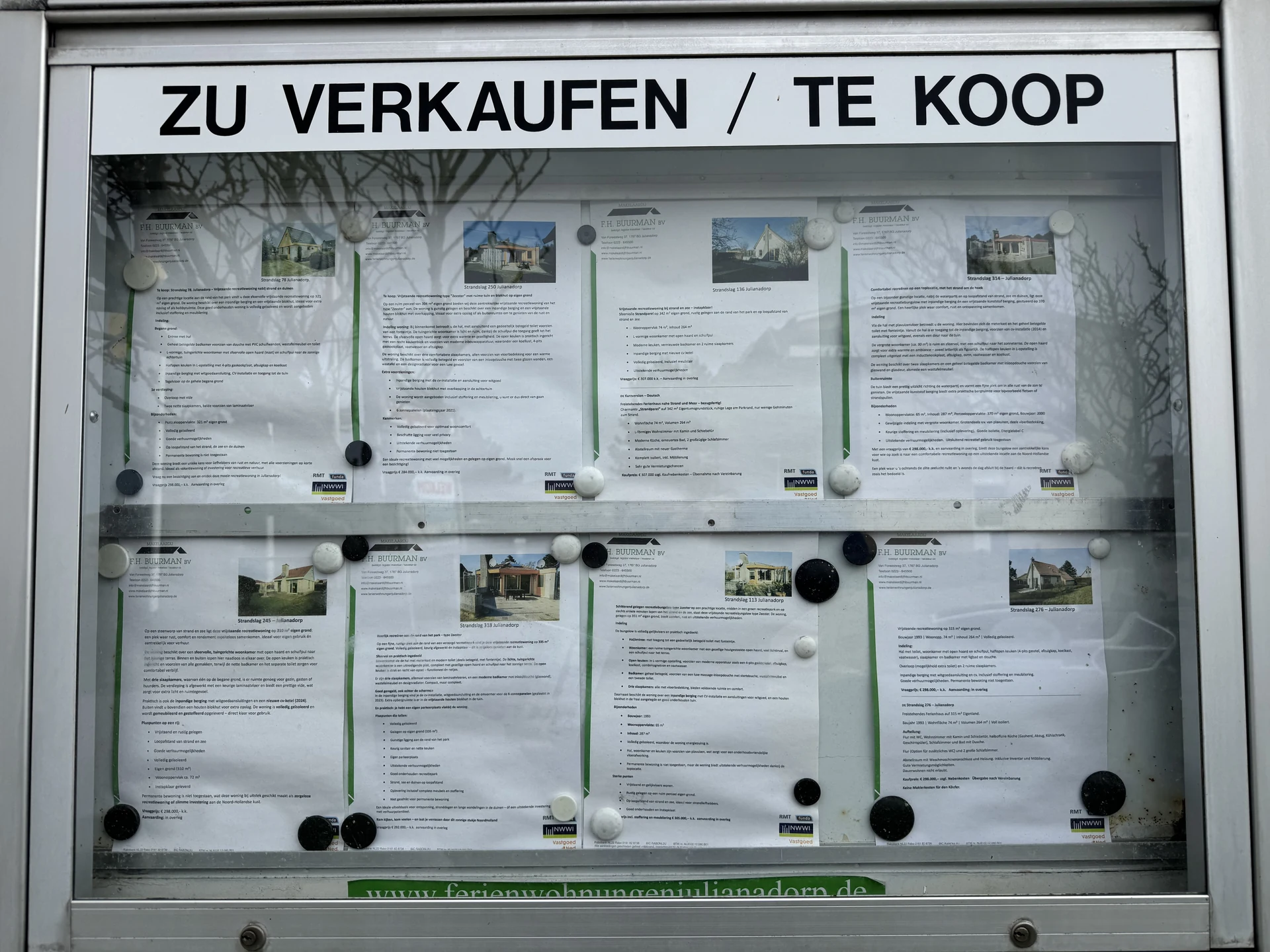 Schaukasten im Bungalowpark Strandslag mit Exposés von acht Bungalows, die zum Verkauf stehen